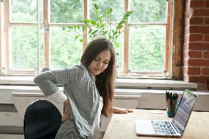 Woman At Desk Experiencing Back Pain