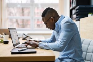 Man On Computer With Bad Posture