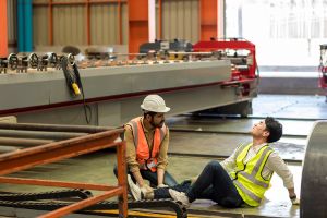 Two workers. One with an injured ankle and the other helping to hold it straight.